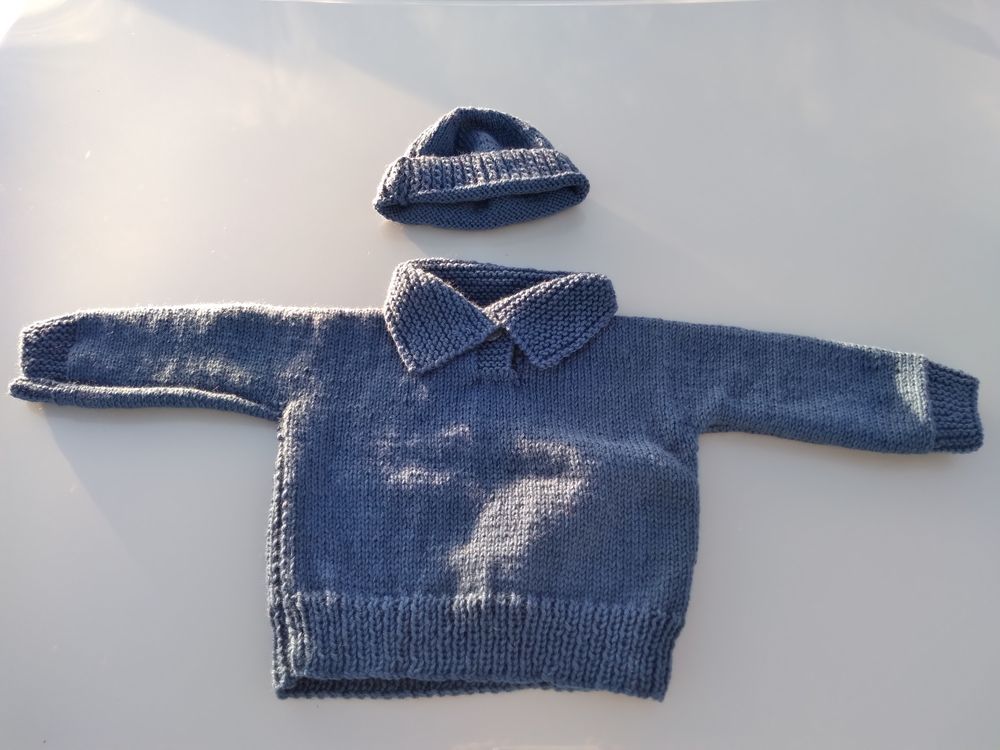 A hand-knitted baby jumper and beanie made from alpaca yarn